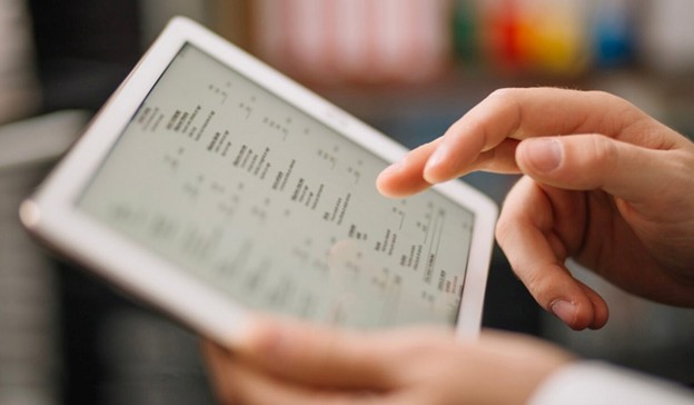 Person using a digital tablet to review spreadsheet data