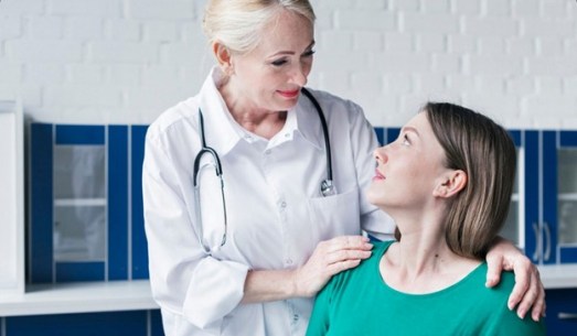 Female doctor placing hand on patient's shoulder for support